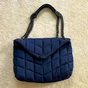 Navy puffer shoulder bag with black chain and leather straps